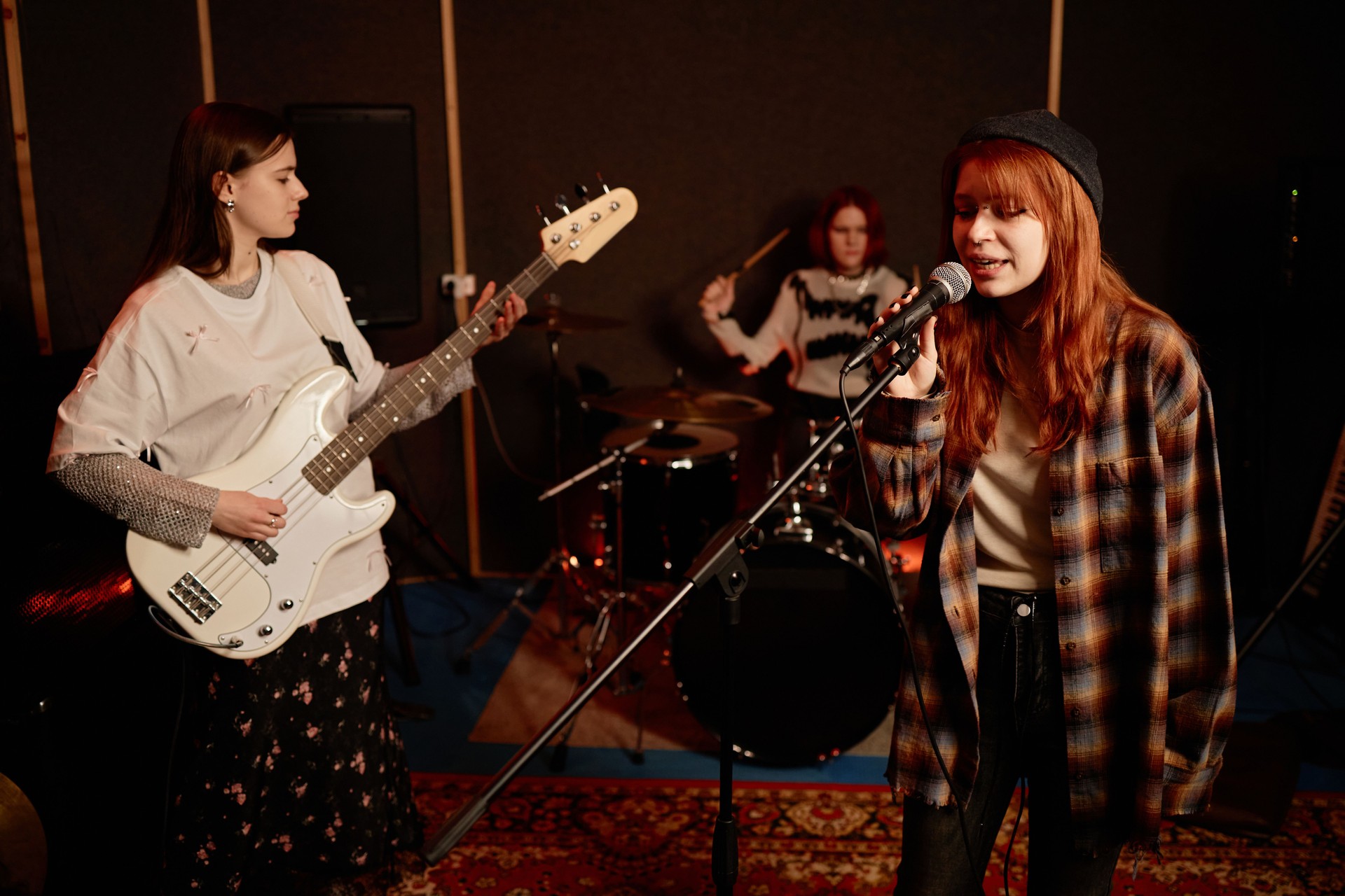 Young Girl Singing into Mic Playing New Song with Girl Rock Band in Recording Studio